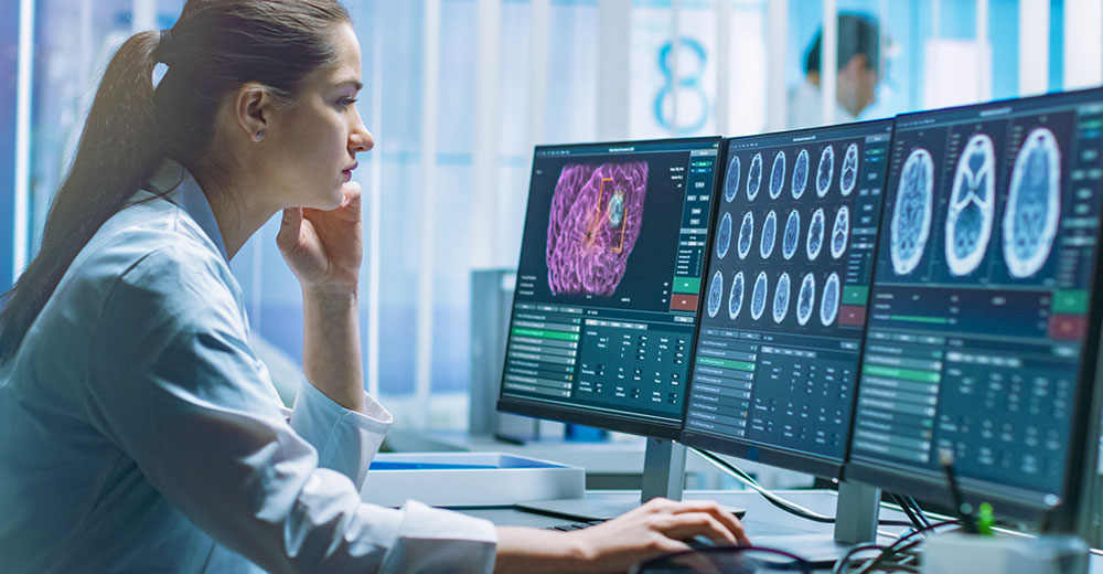 Female radiologist analyzing medical scans on multiple monitors with CT and MRI images